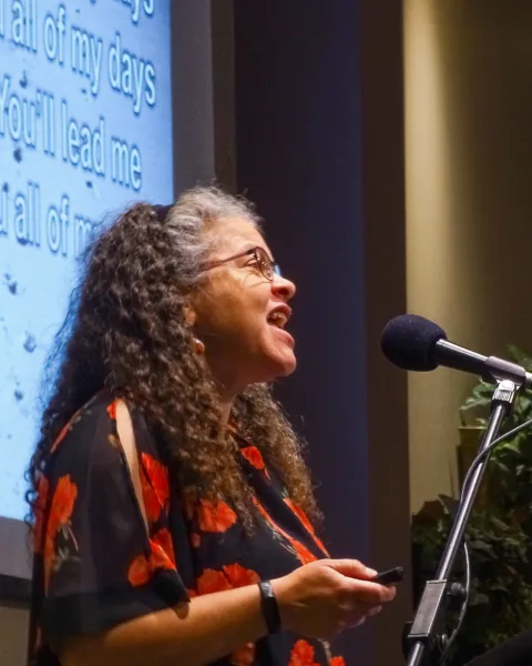 Woman speaking into a microphone at SK Church