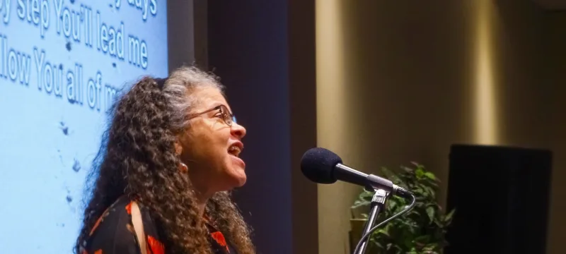 Woman speaking into a microphone at SK Church